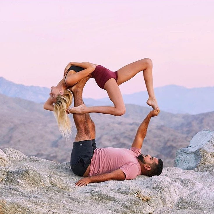 @couplegoalsnew1 performing a yoga pose while wearing Alo.